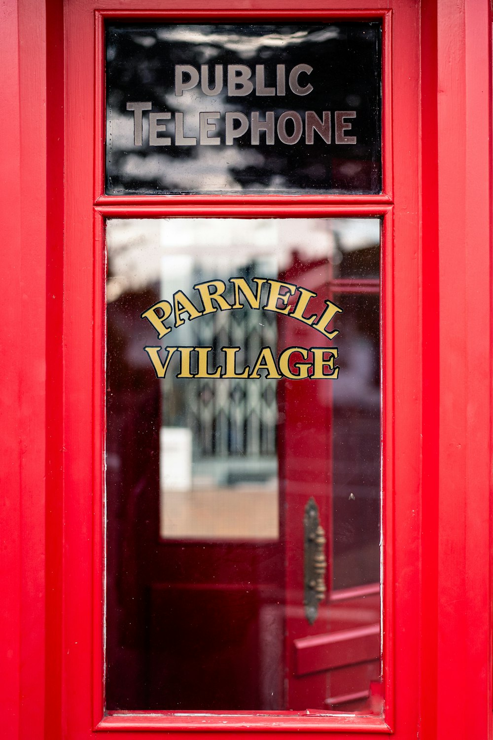 a red telephone booth with a sign on it