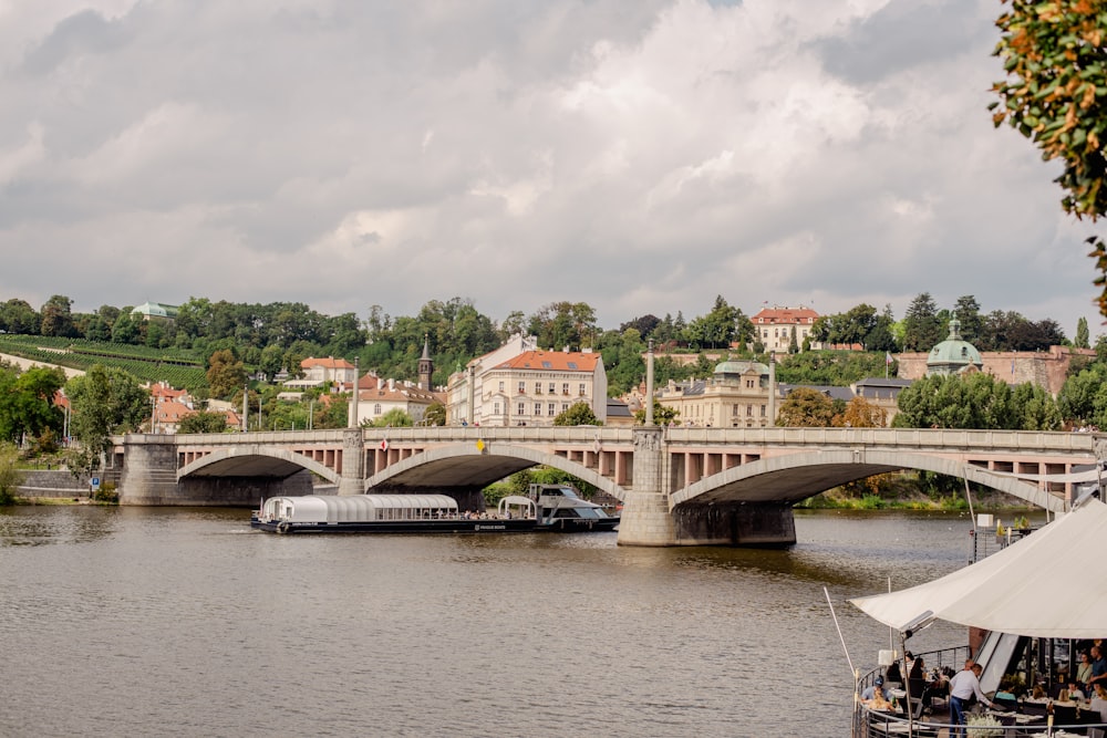 a boat traveling down a river next to a bridge