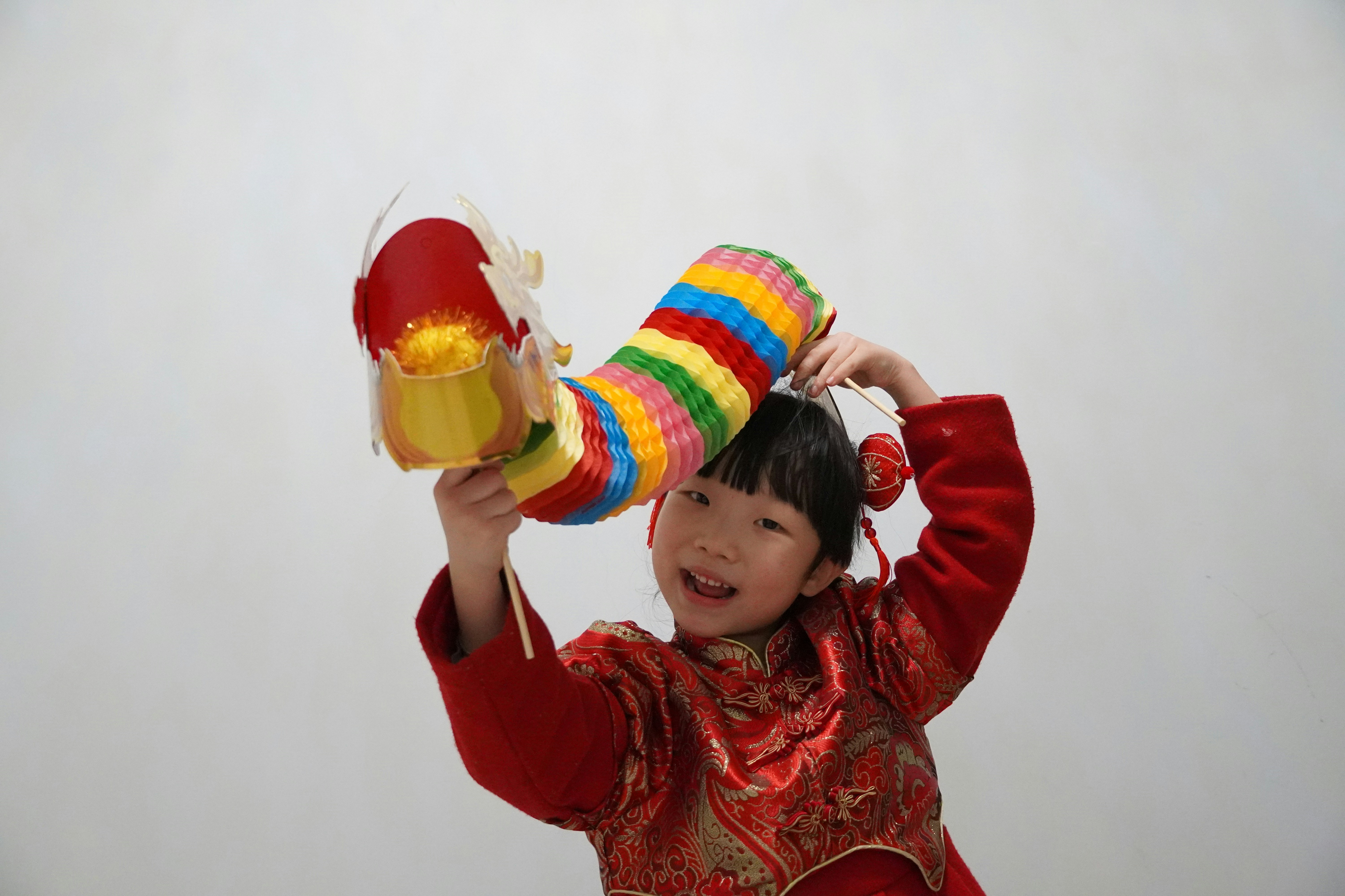 a young child wearing a colorful hat and holding a toy