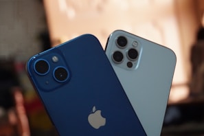 two blue and white iphones sitting next to each other