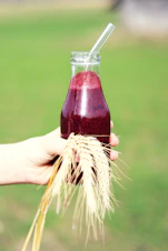a person holding a glass of juice in their hand