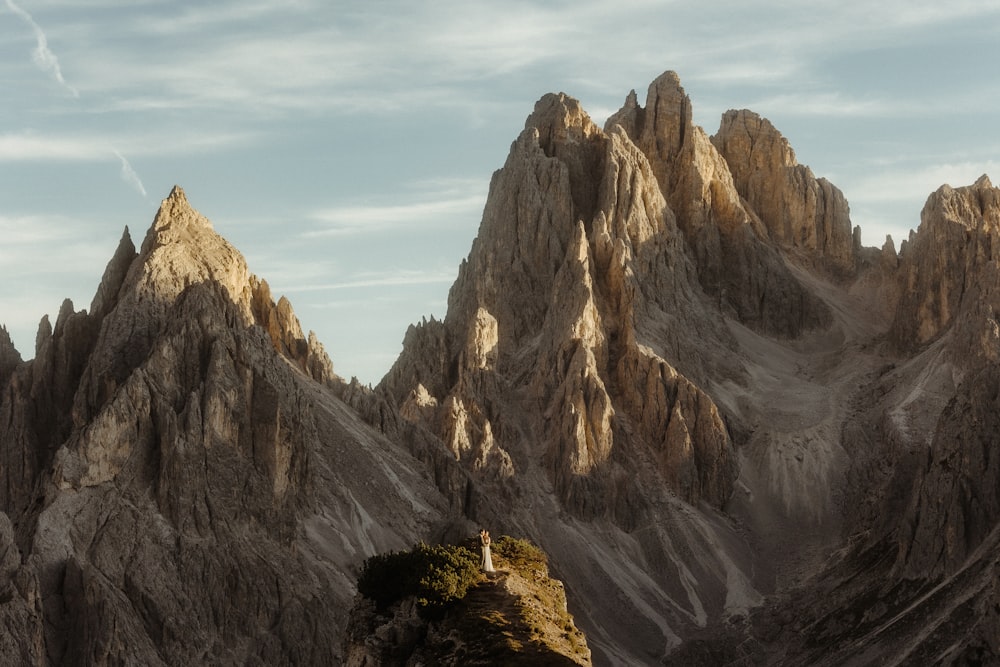 a person standing on a rock outcropping in the mountains