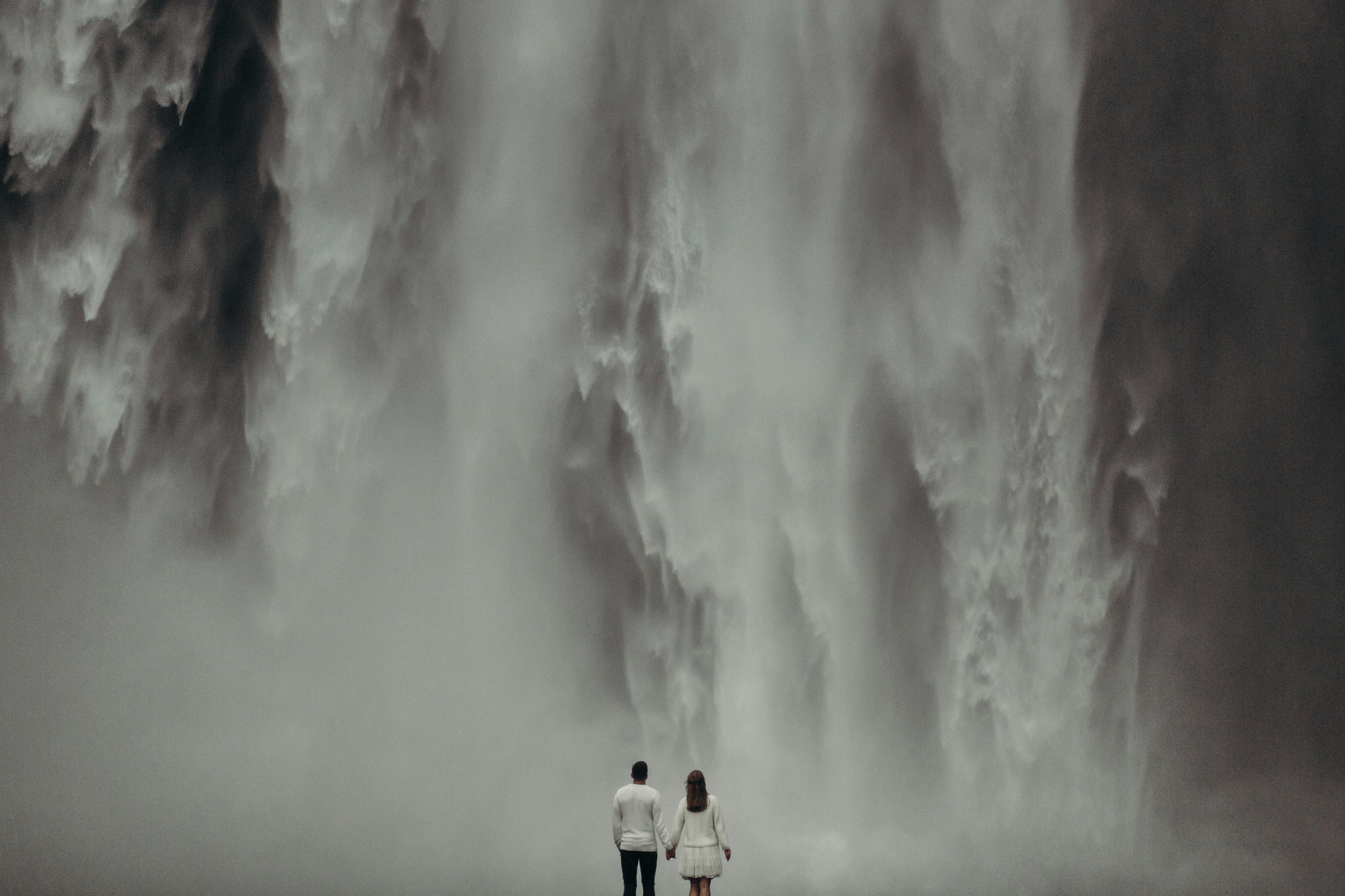 A man and a woman standing in front of a waterfall photo – Free Grey ...