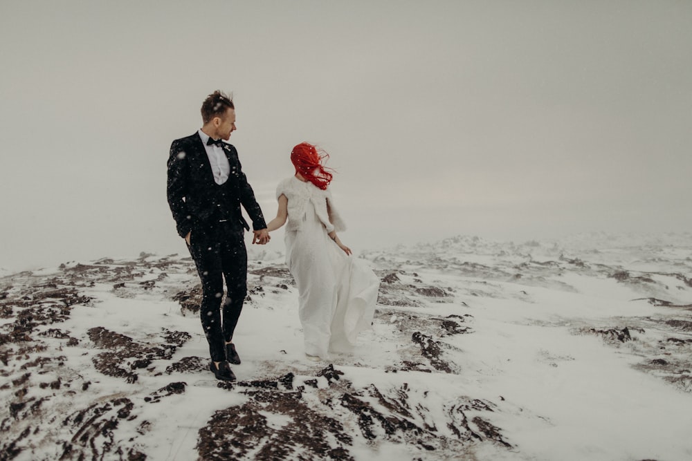 a man and a woman are walking in the snow