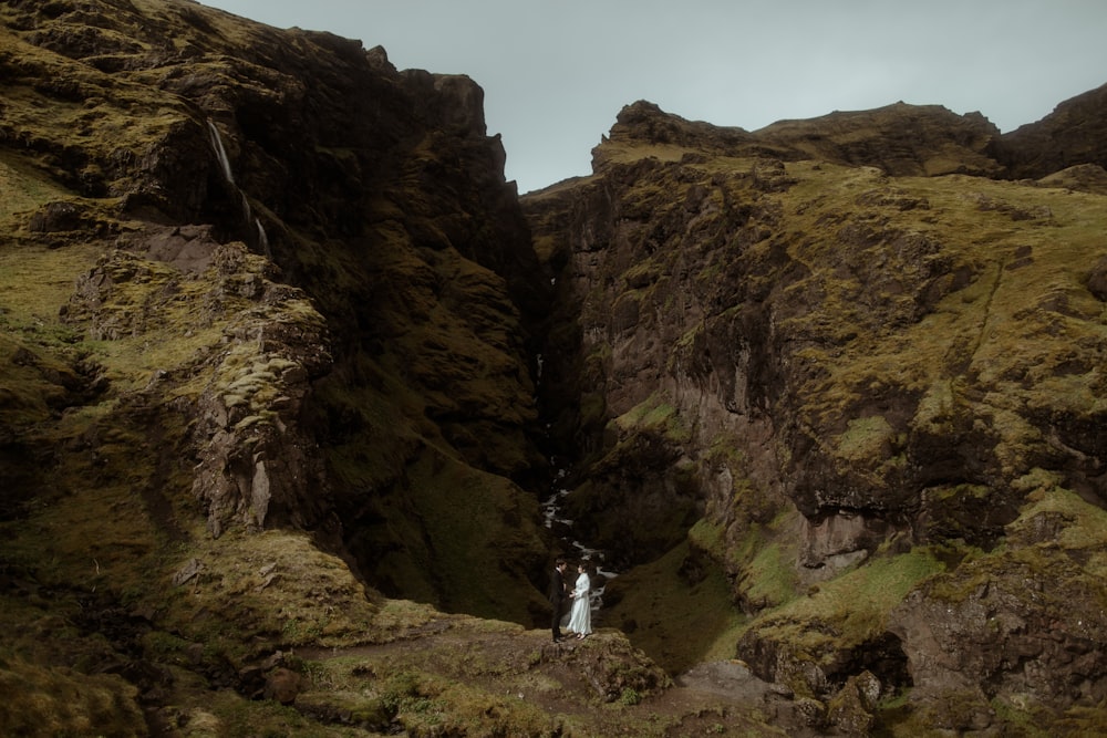 a narrow canyon with a waterfall in the middle of it