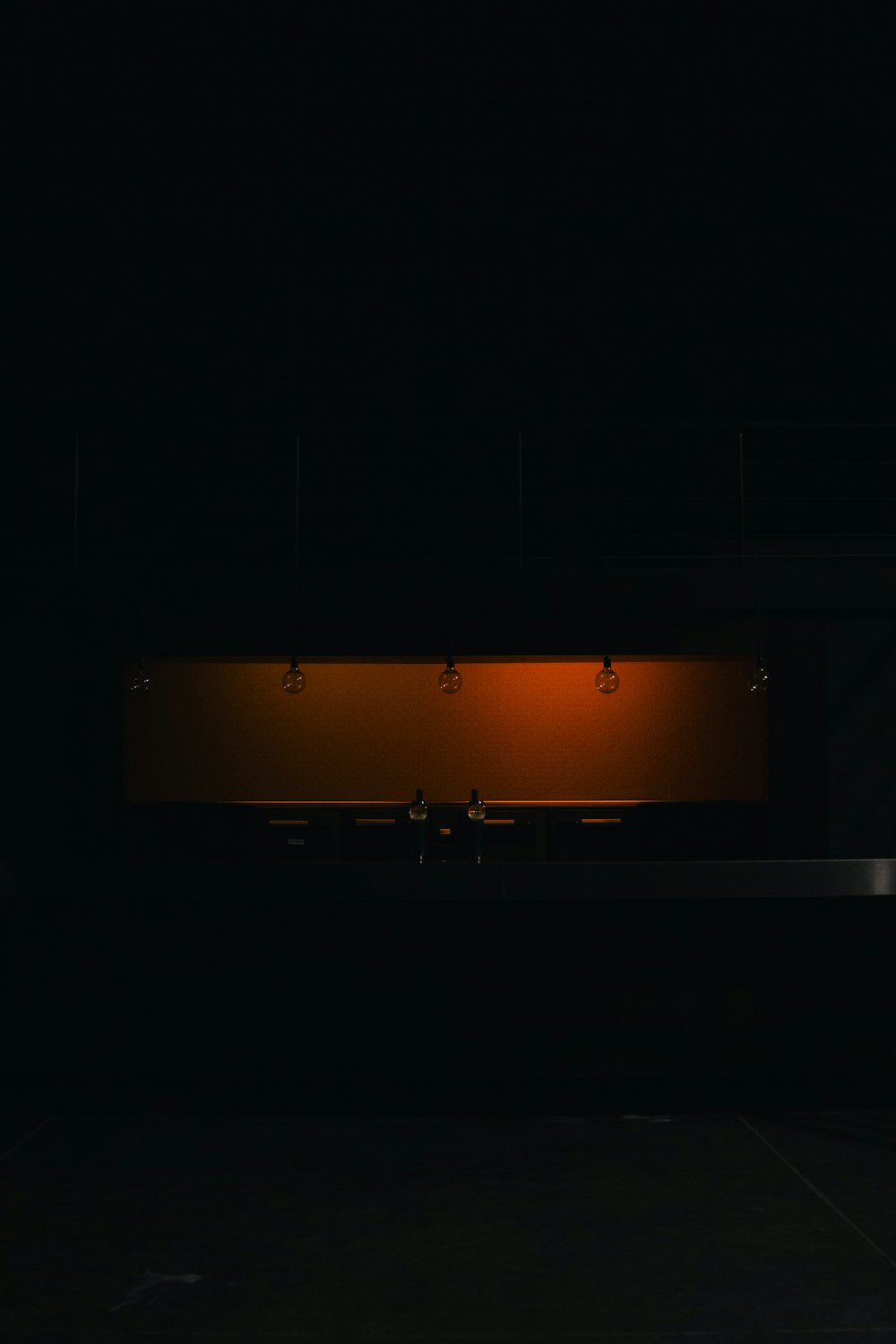 a dark room with a bench and lights