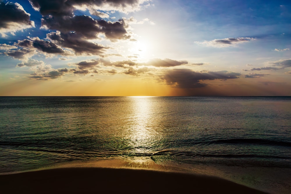 the sun is shining through the clouds over the ocean