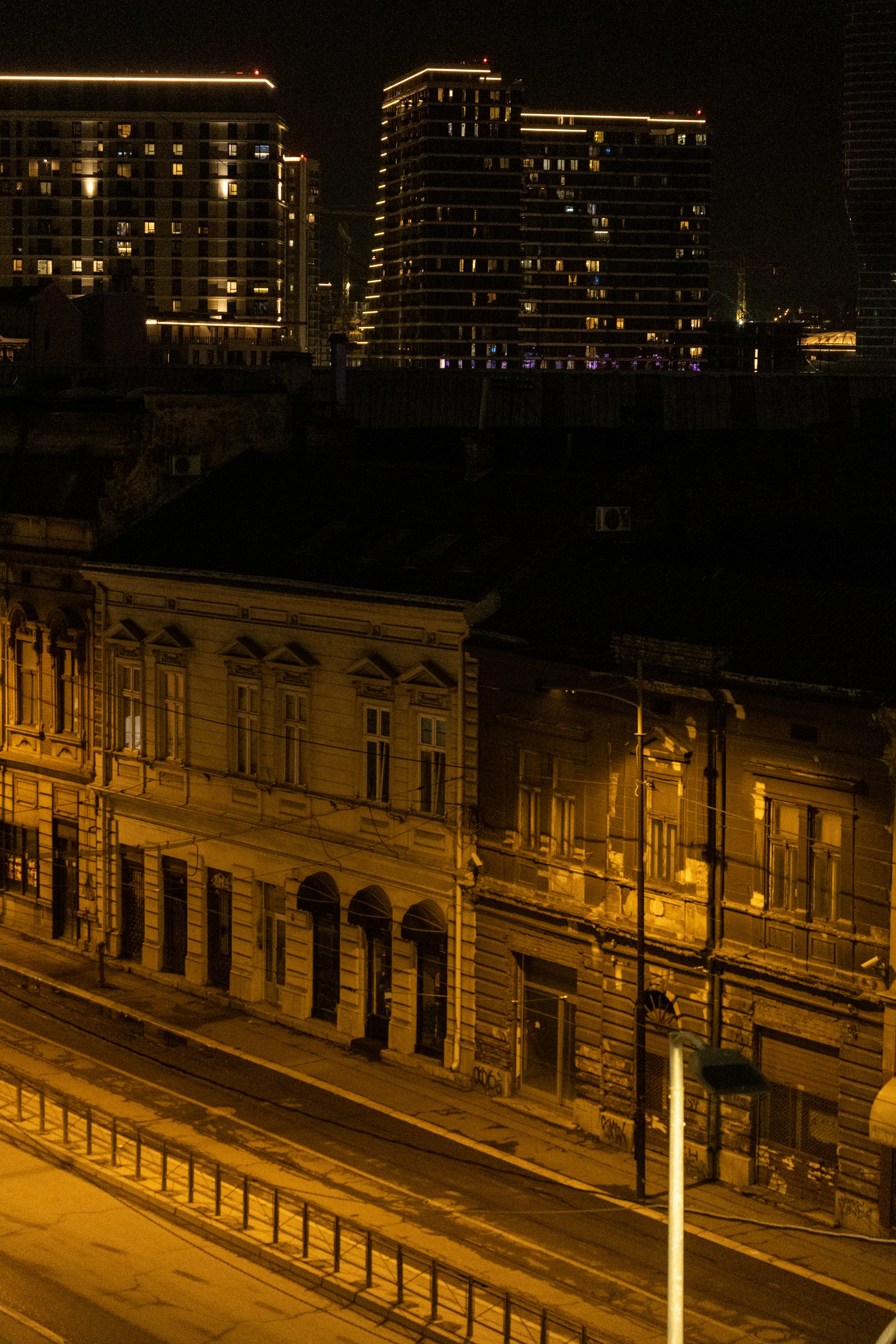 a city street at night with buildings in the background