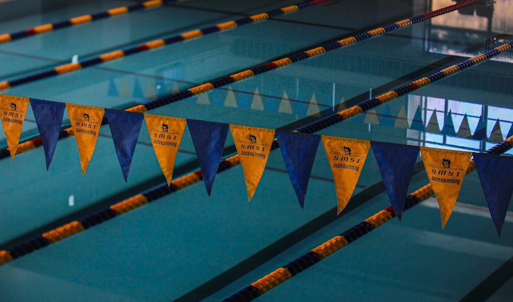 a swimming pool with blue and yellow flags