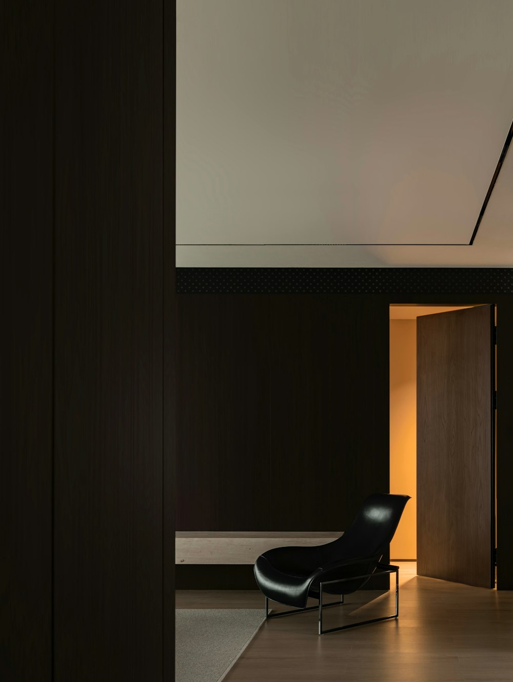 a black chair sitting in a room next to a doorway