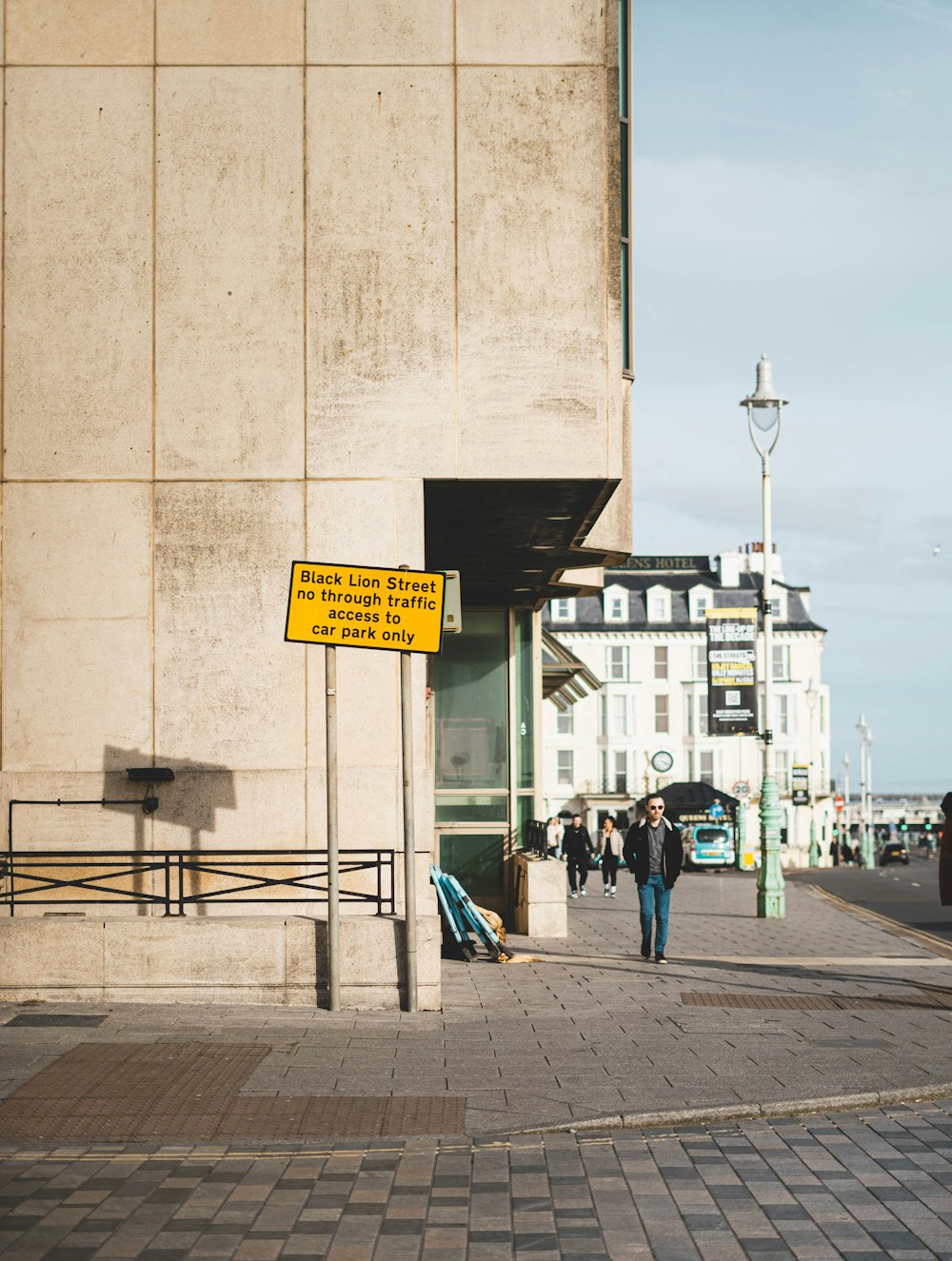 a person walking down a sidewalk next to a tall building