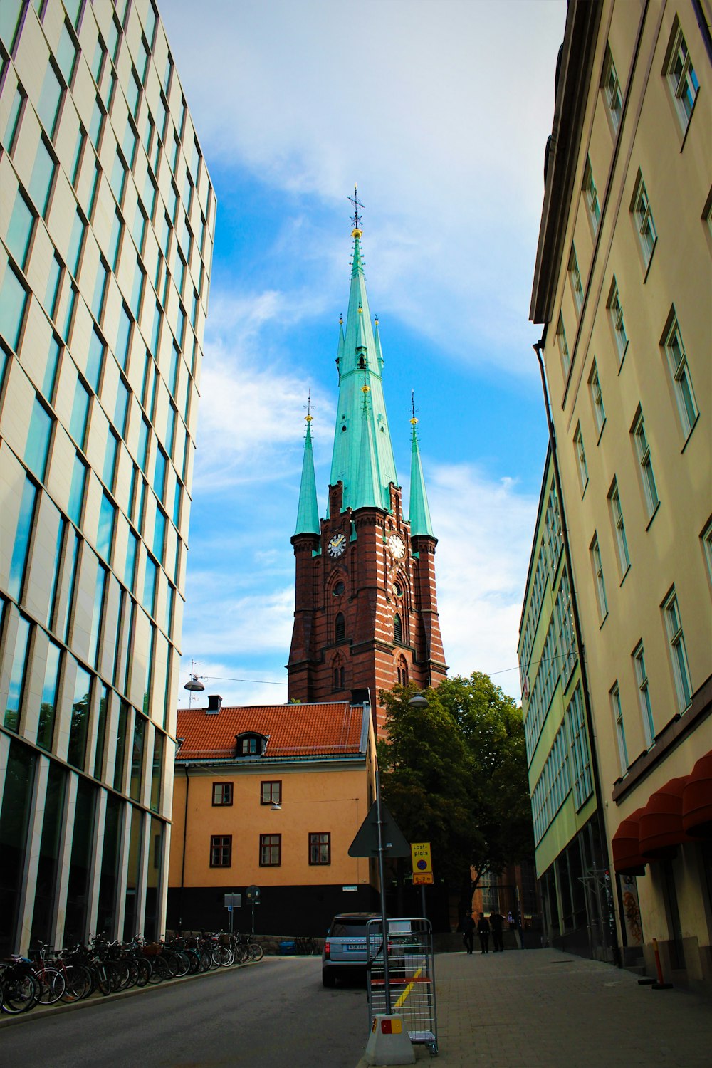 a clock tower towering over a city next to tall buildings