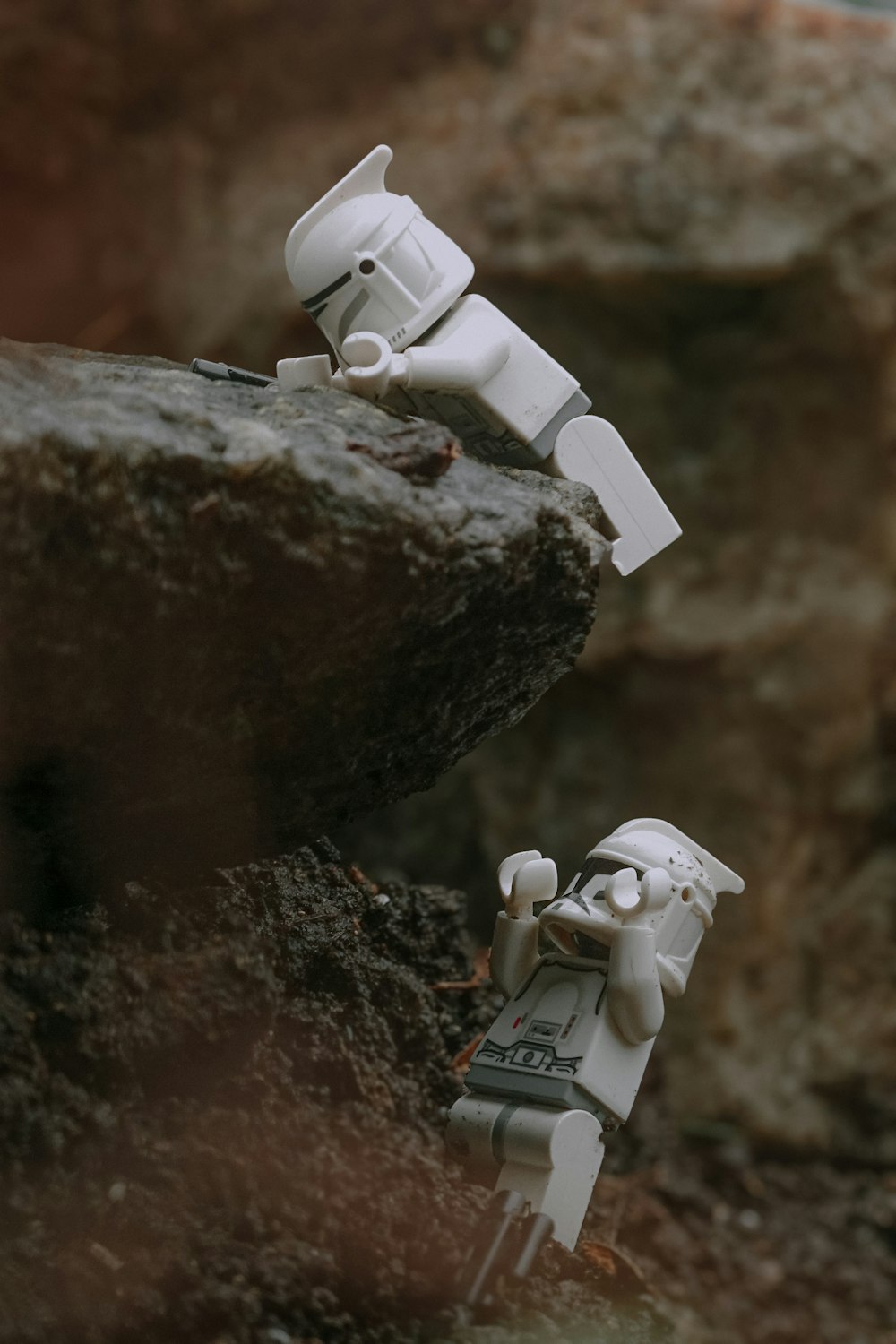um par de figuras de brinquedo sentado em cima de uma rocha