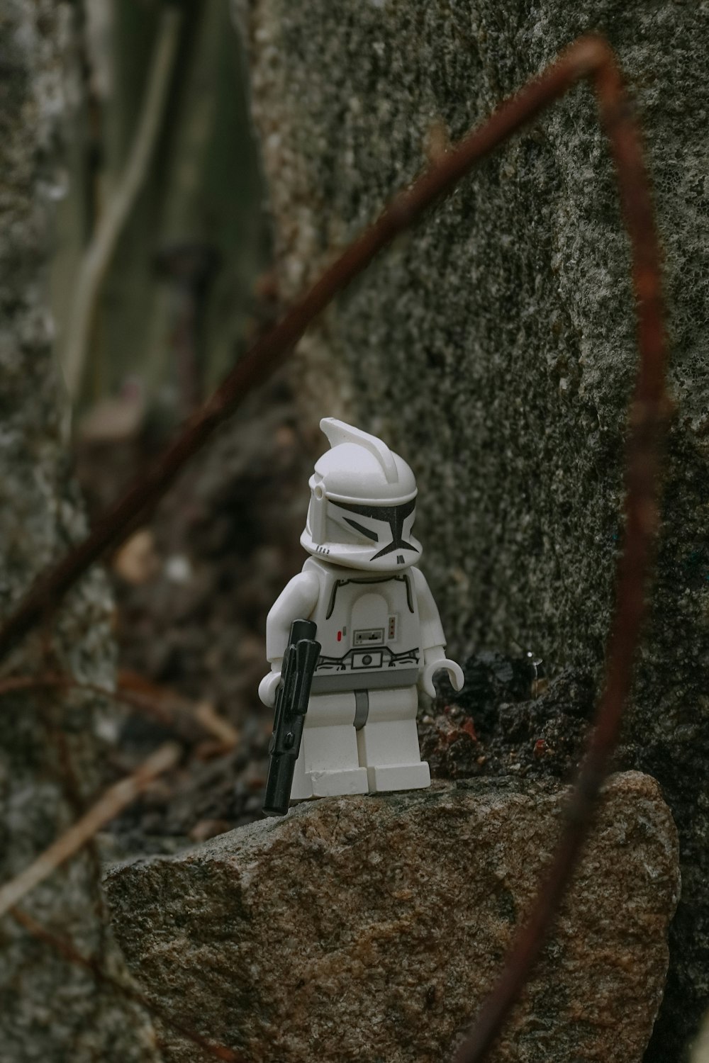 a lego stormtrooper is sitting on a rock