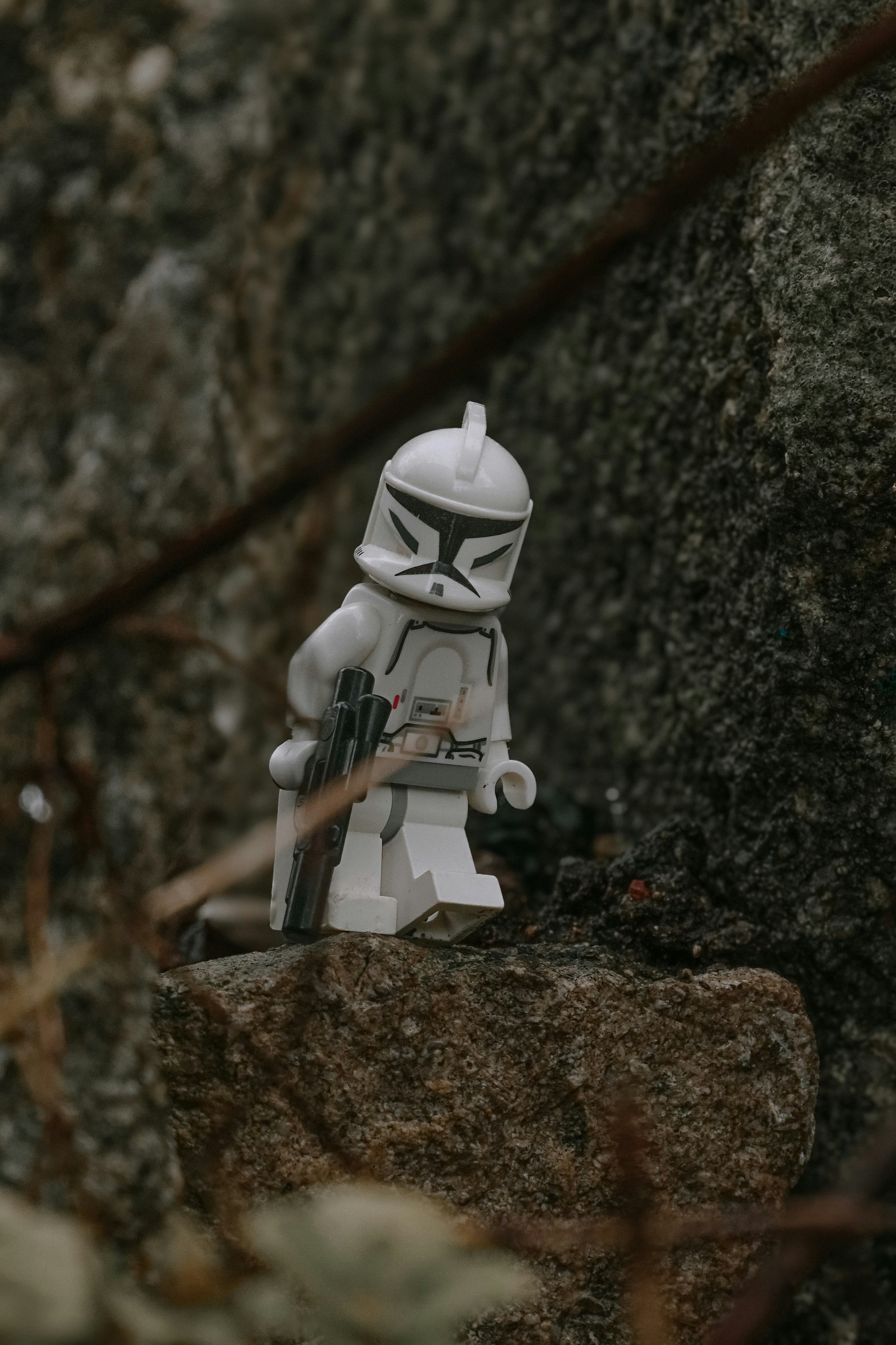 a lego storm trooper sitting on top of a rock
