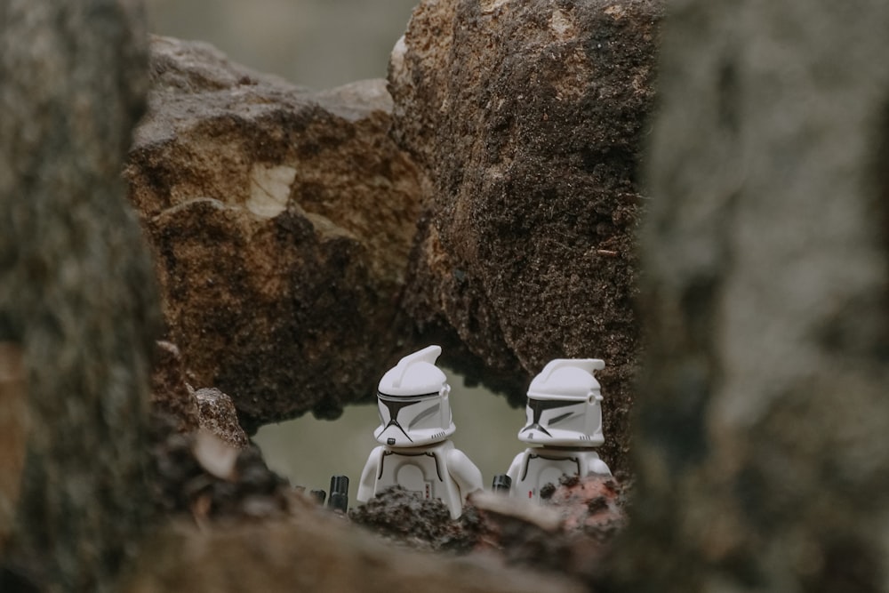 a pair of storm trooper figurines sitting on top of a rock