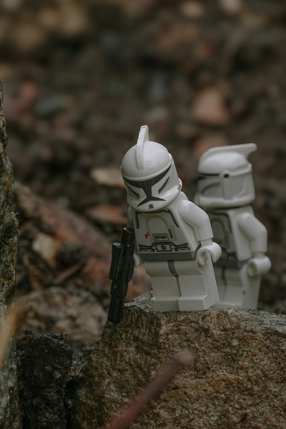 a lego storm trooper and storm trooper sit on a rock