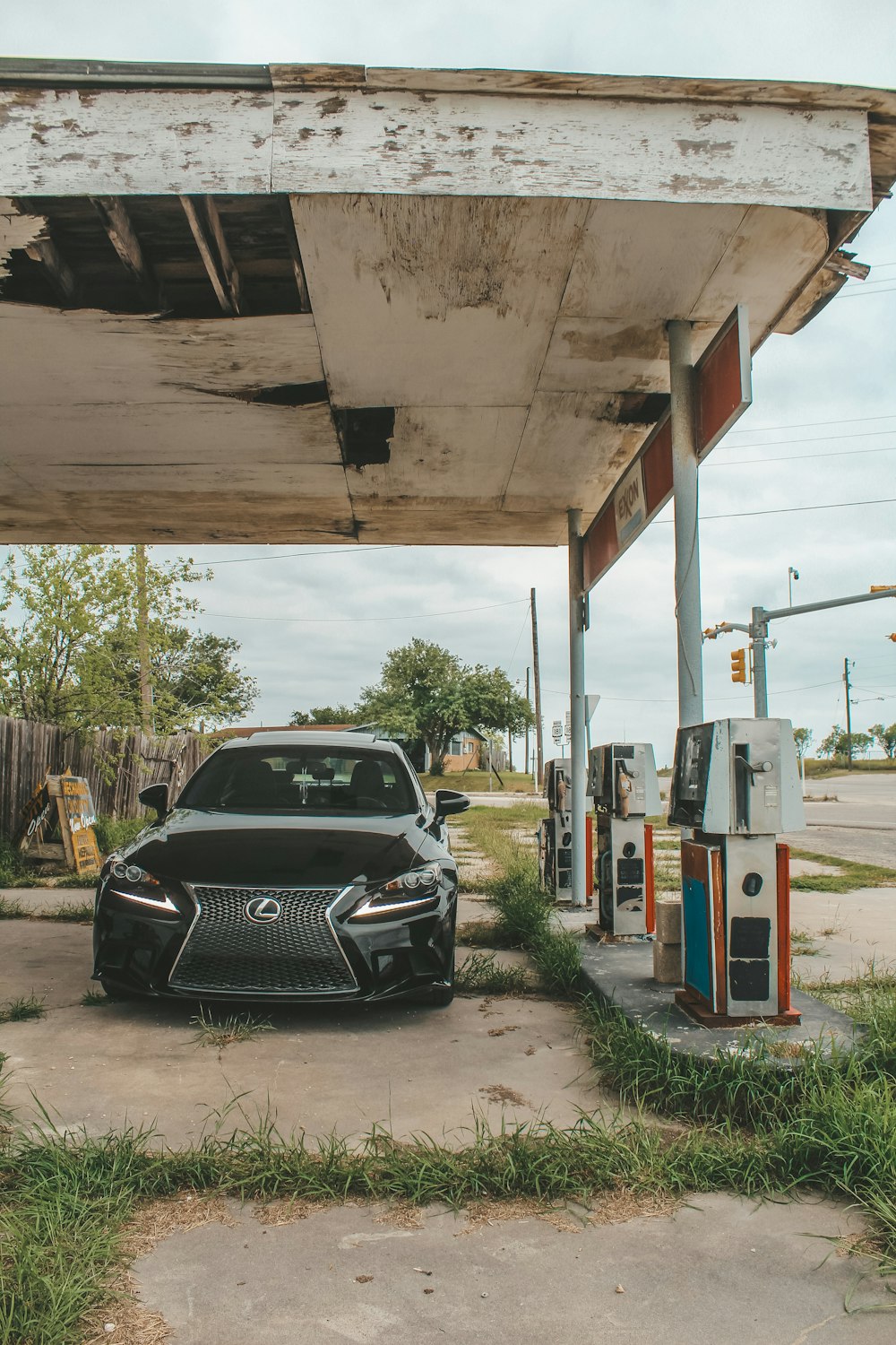 a black car parked in front of a gas station