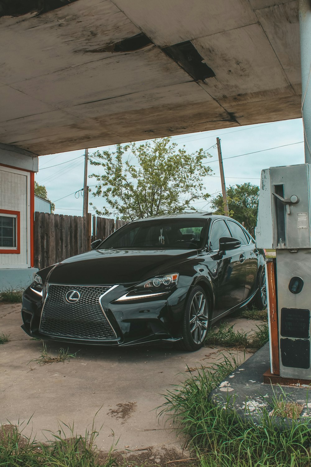 a black car is parked under an overpass