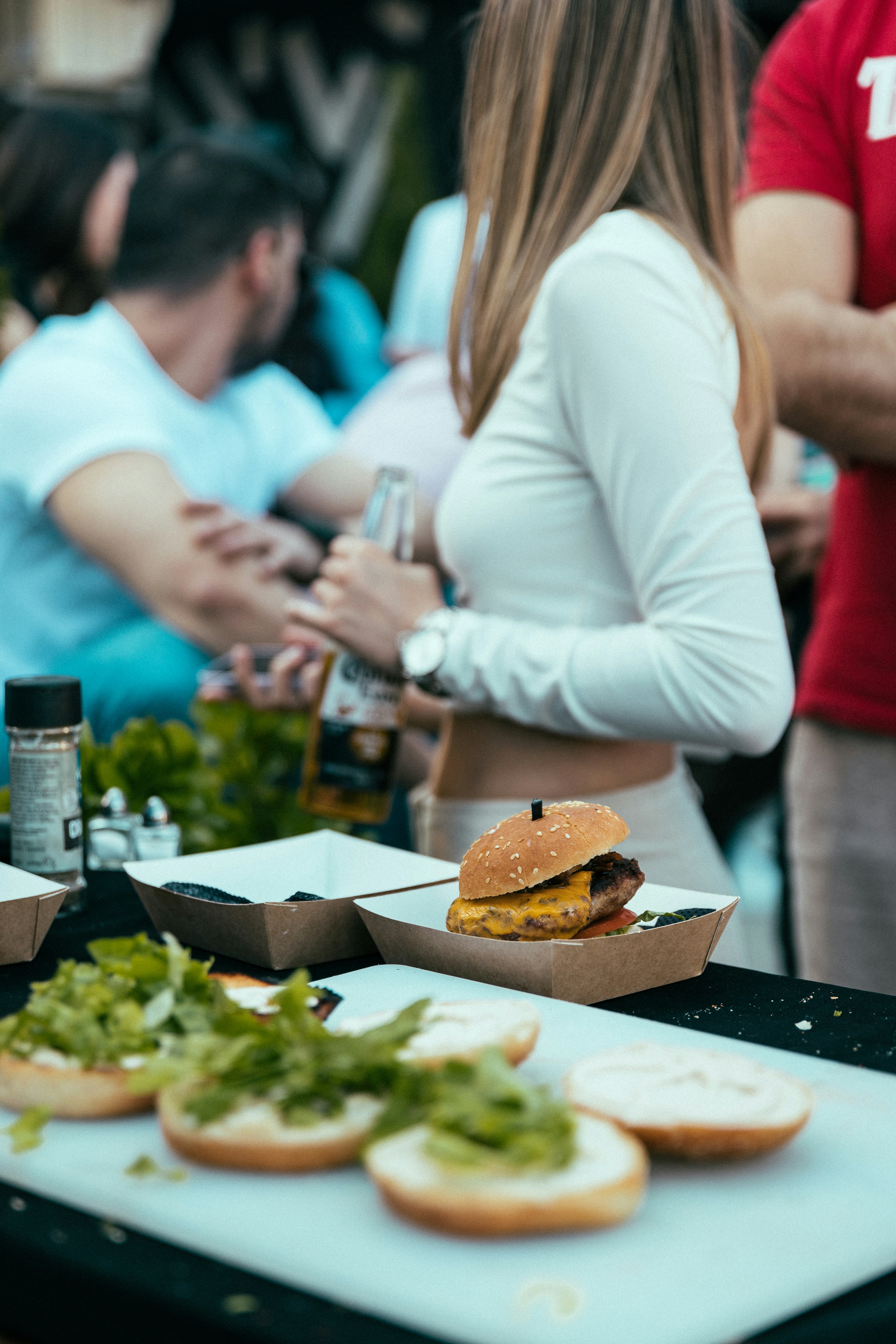 A group of people standing around a table with food on it photo – Free ...