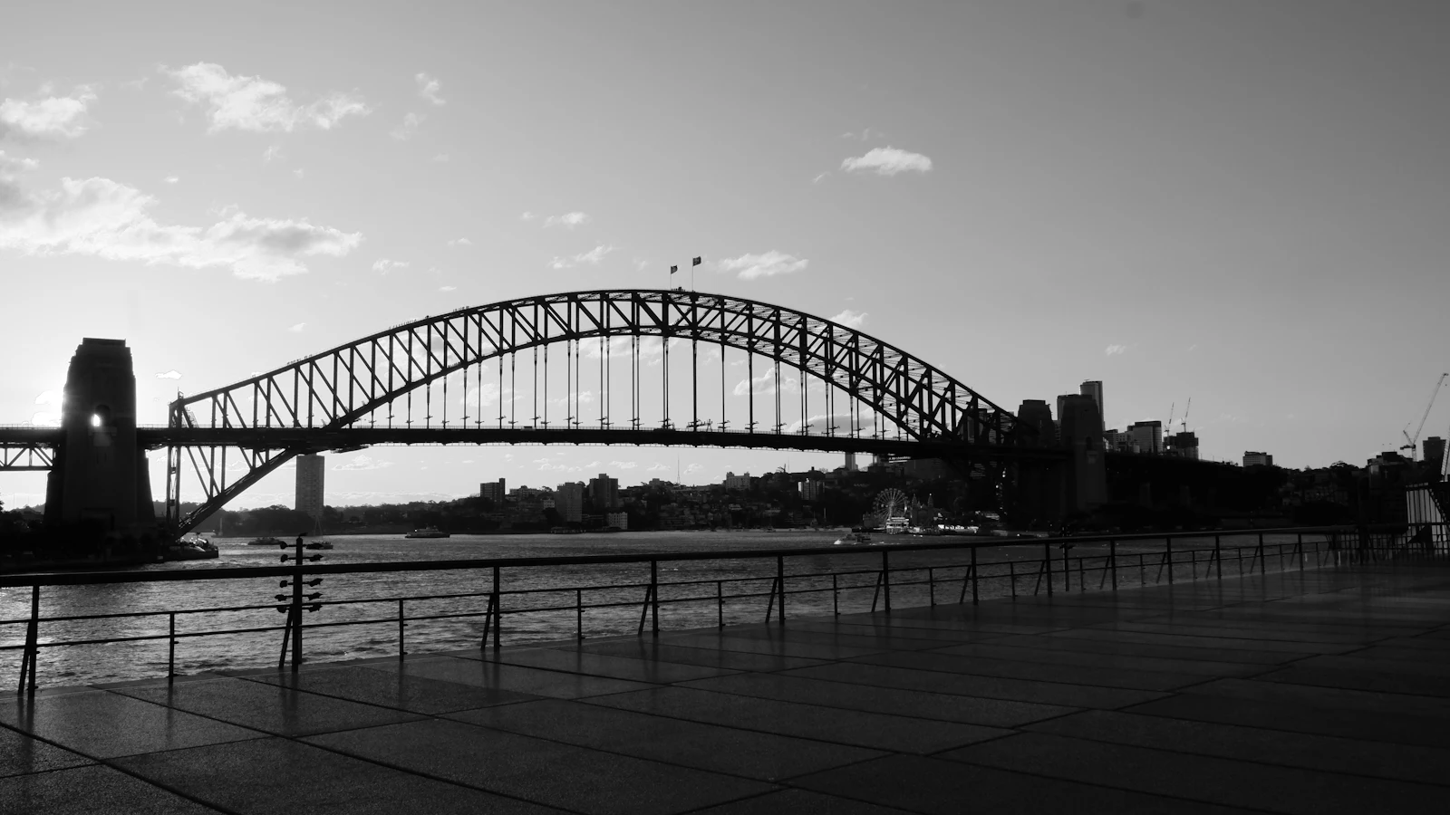 Black and white photograph of the Sydney Harbour Bridge spanning the water