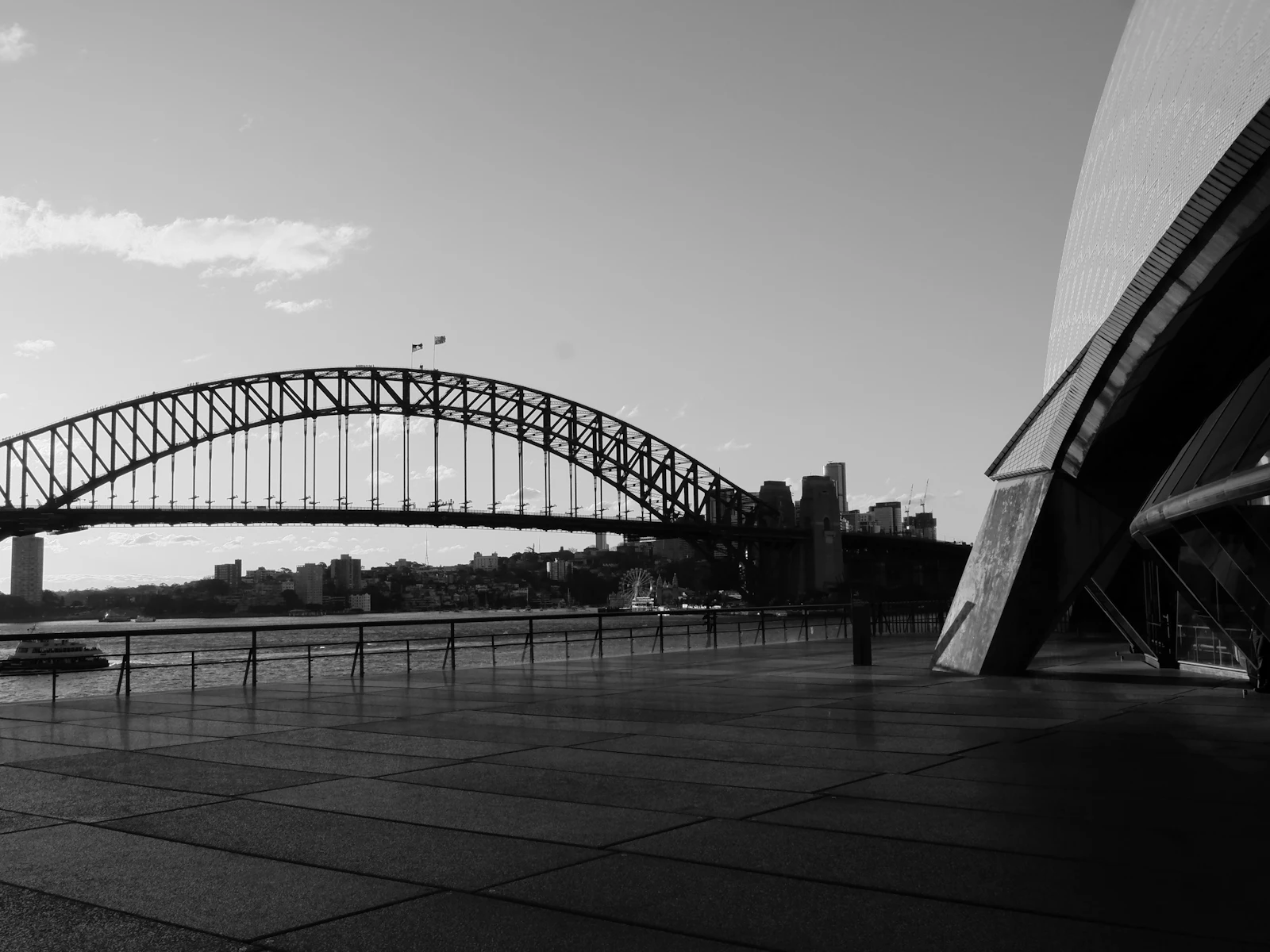 Black and white photograph of the Sydney Harbour Bridge spanning the water