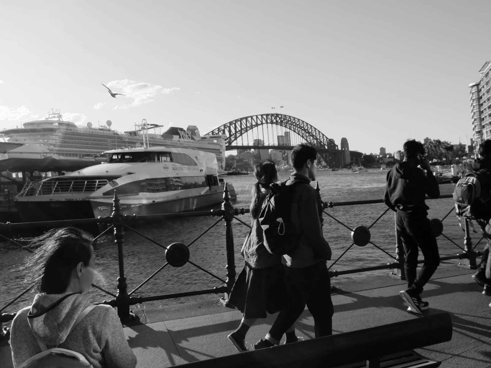 People walking across a bridge in black and white, Australian city commuters