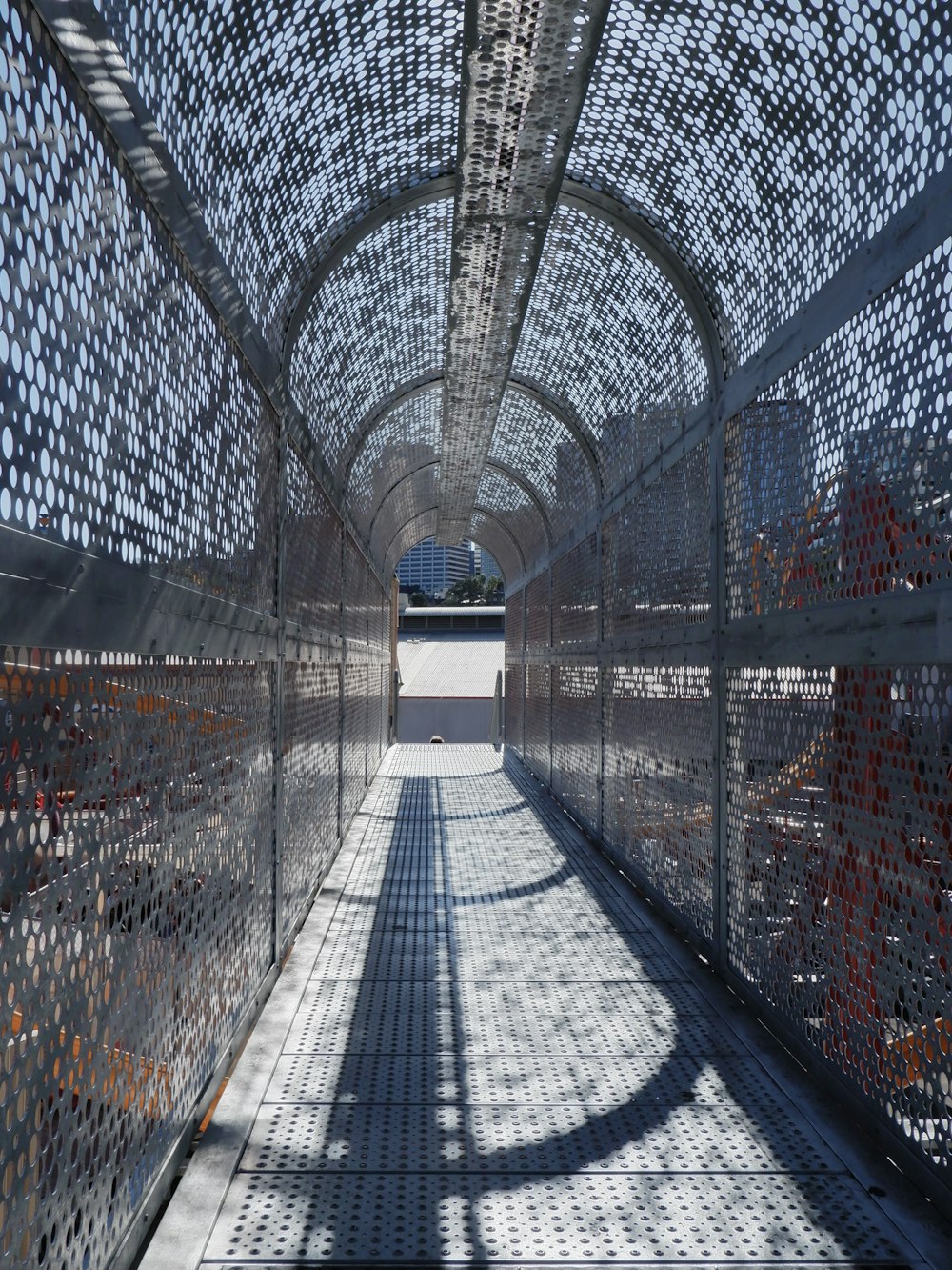 a walkway in a large metal structure with a sky background