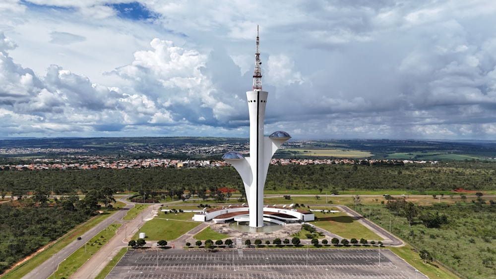 an aerial view of a tall building in the middle of a field