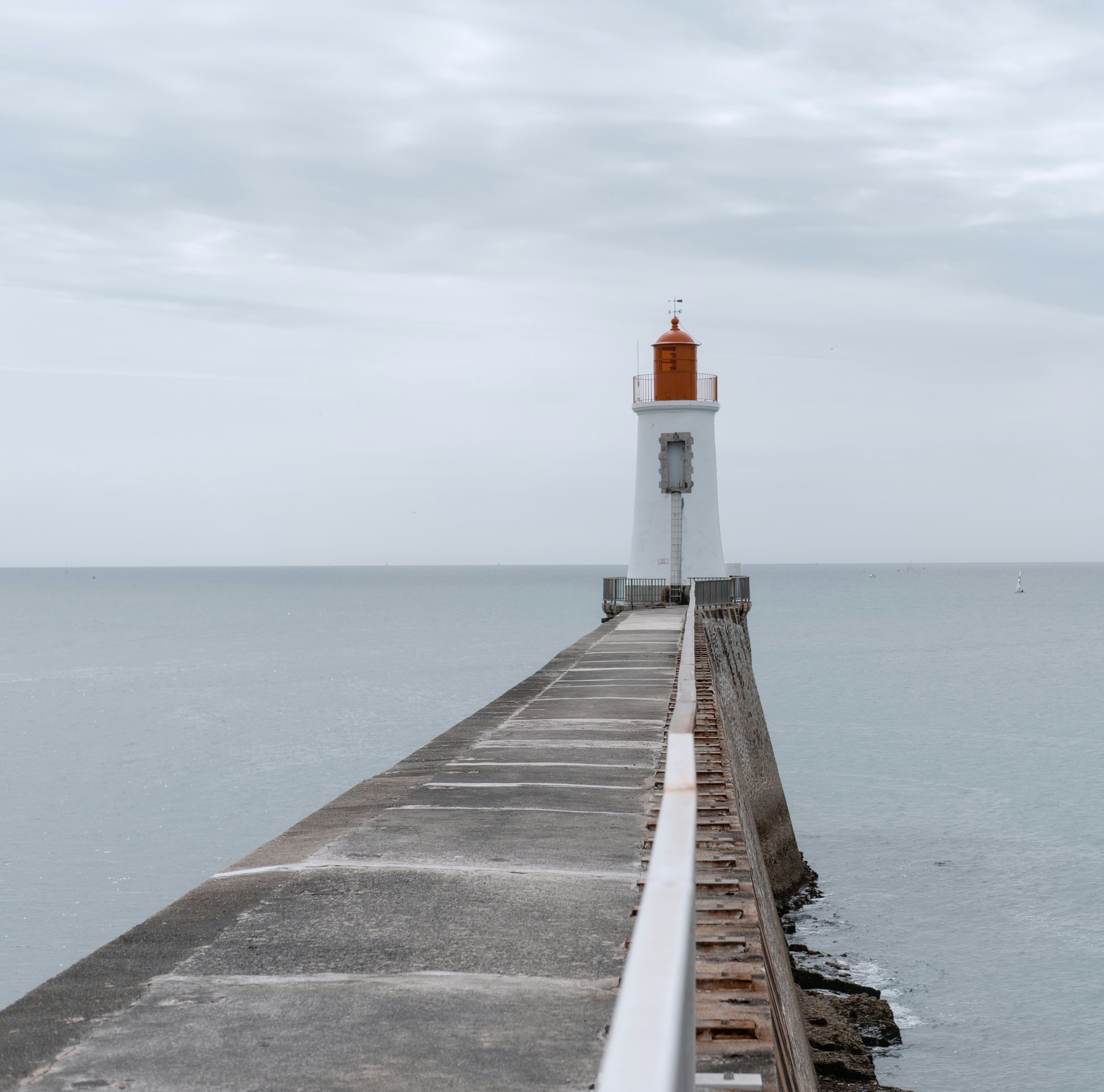 a light house sitting on top of a pier next to the ocean