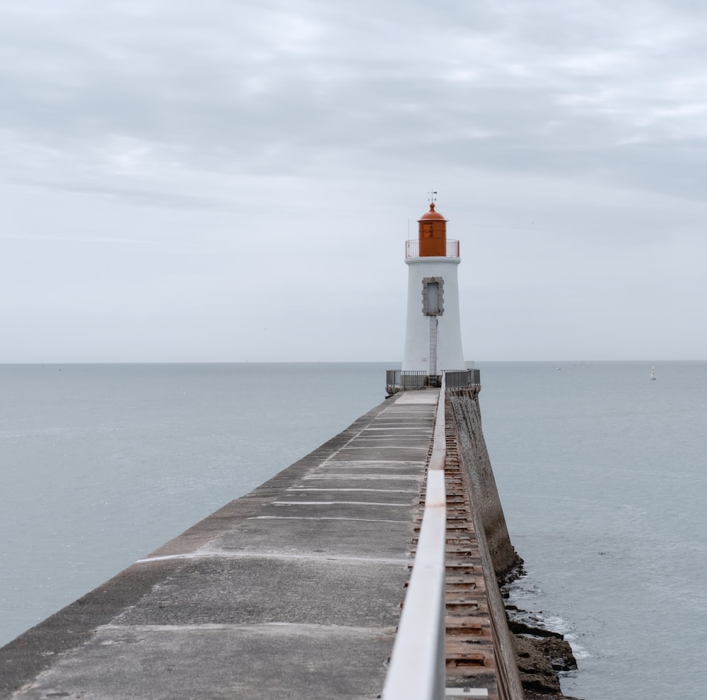 a light house sitting on top of a pier next to the ocean