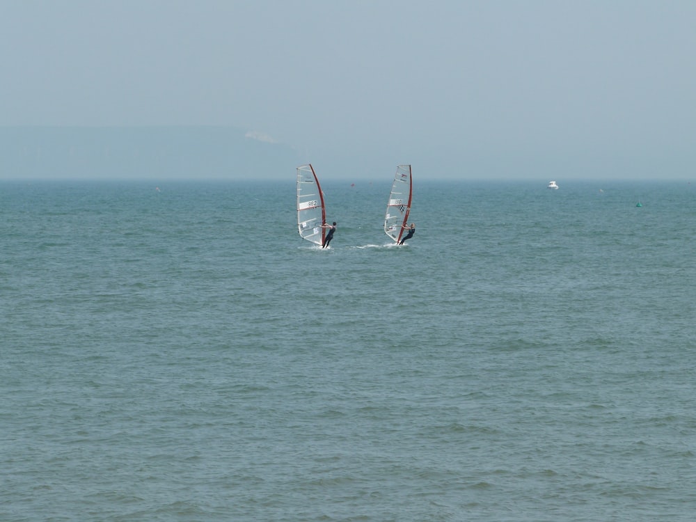 a couple of sail boats in the middle of the ocean