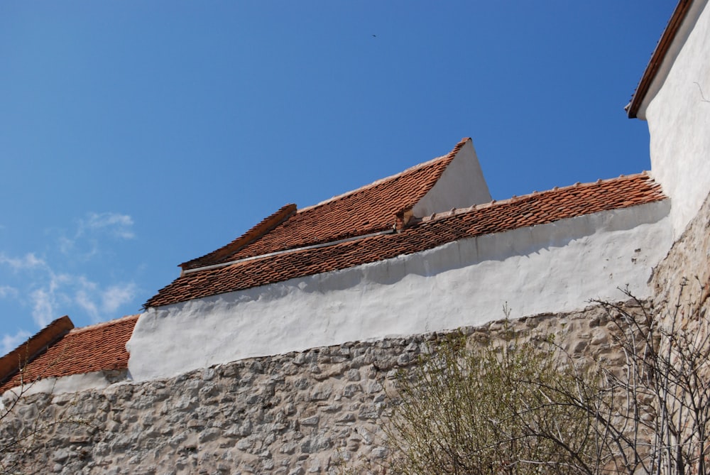 a white building with a red roof and a blue sky