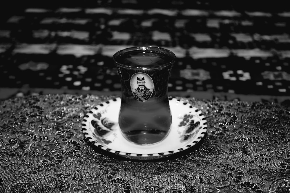 a black and white photo of a glass on a plate