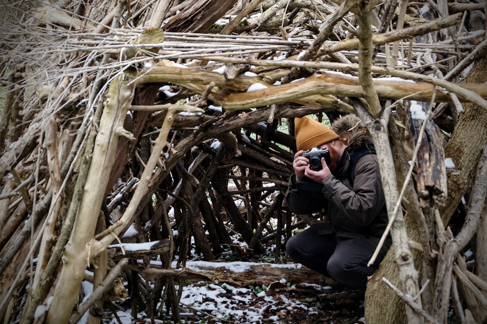 a man taking a picture of a pile of branches