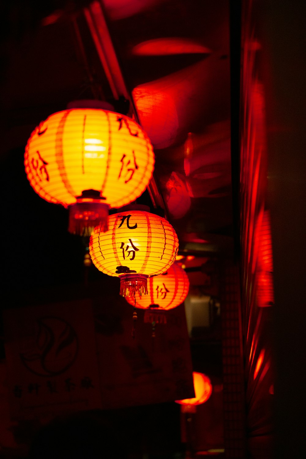 three chinese lanterns lit up in the dark