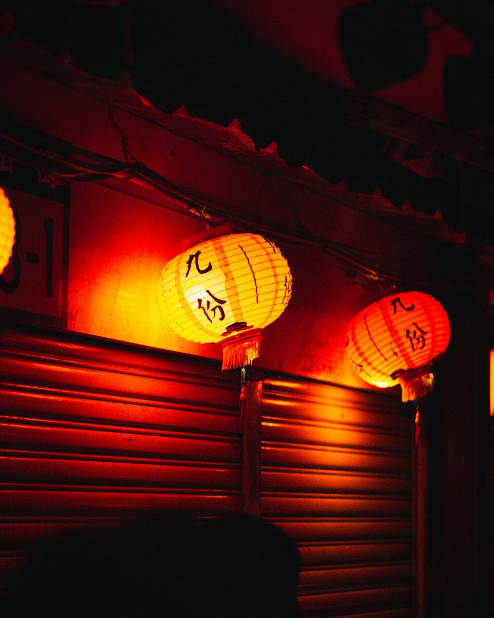 three chinese lanterns lit up in the dark