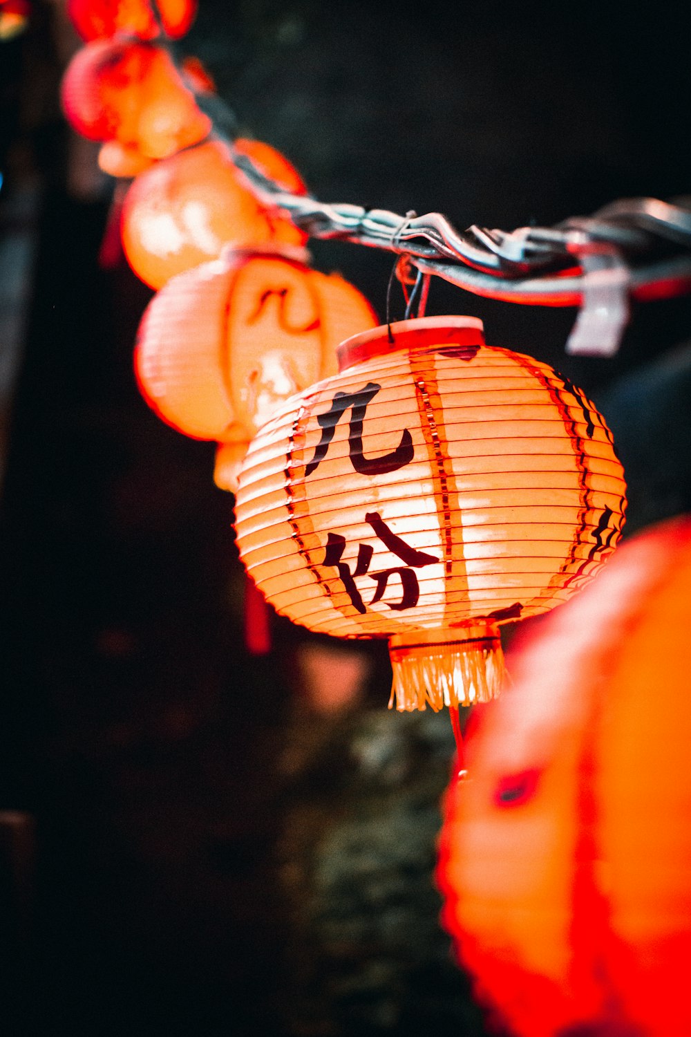 a string of chinese lanterns with writing on them