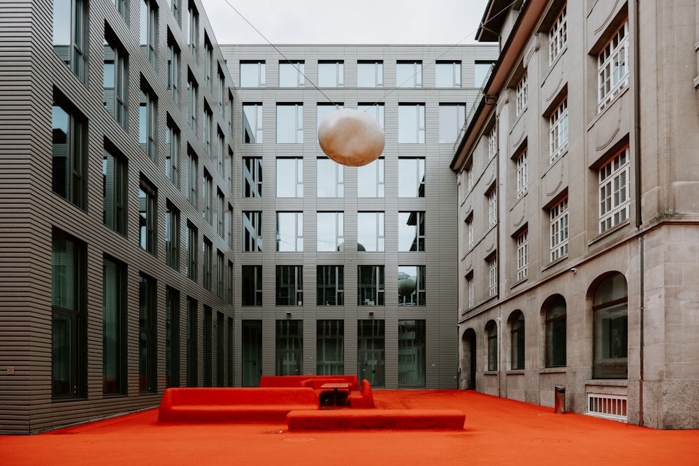 a red bench sitting in the middle of a courtyard
