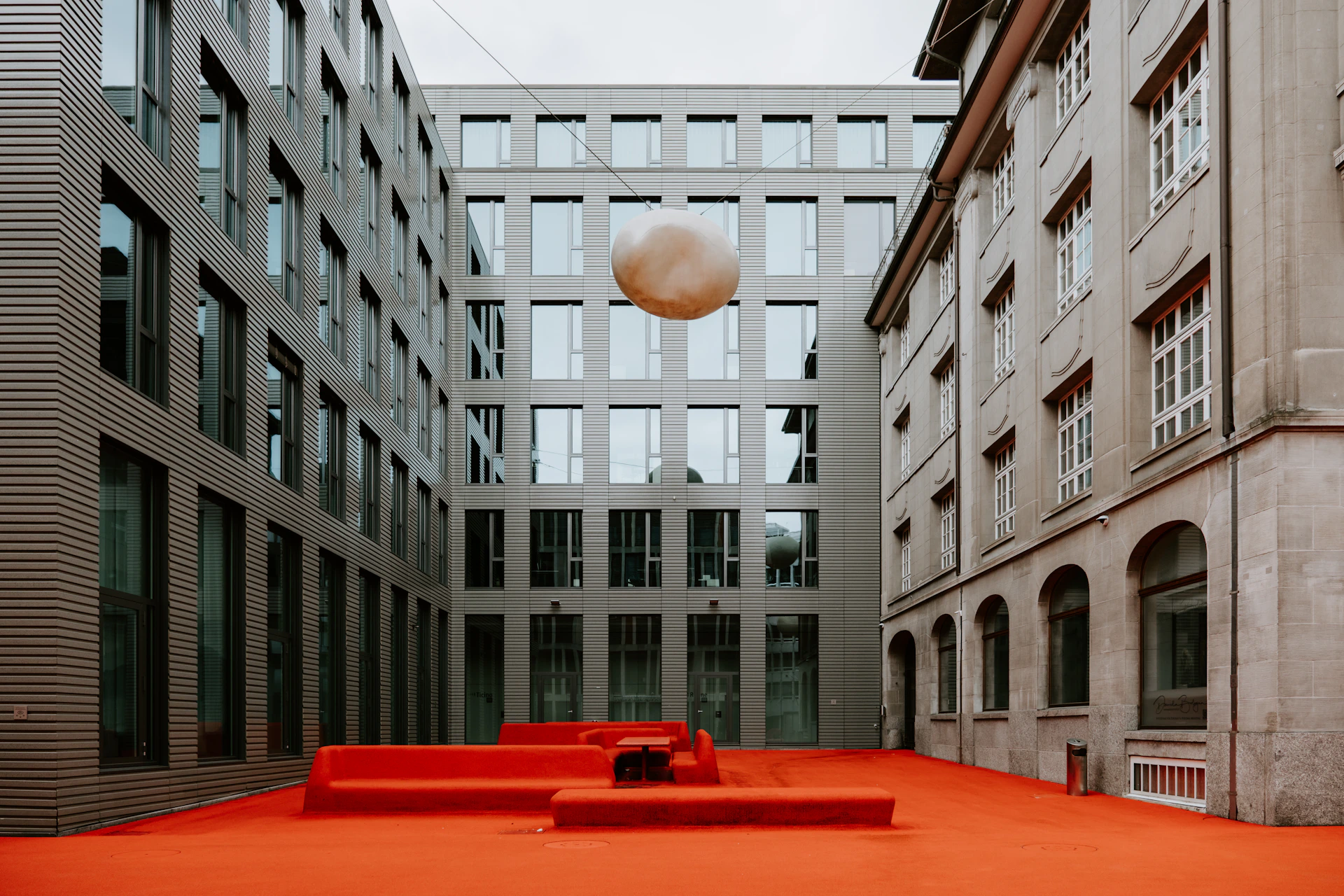 a red bench sitting in the middle of a courtyard