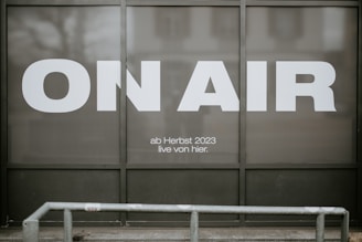 a sign that says on air in front of a building