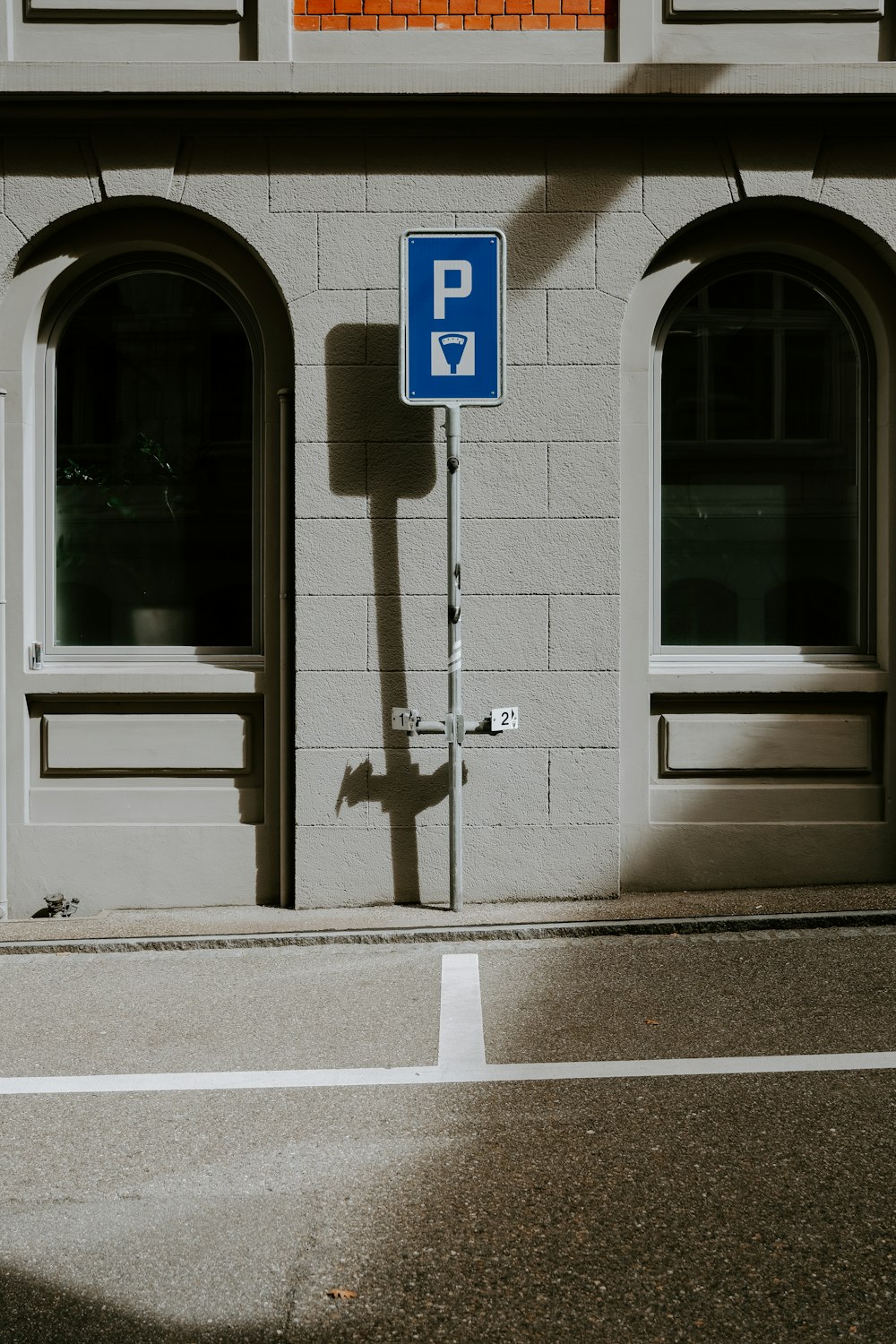 a blue parking sign sitting on the side of a building