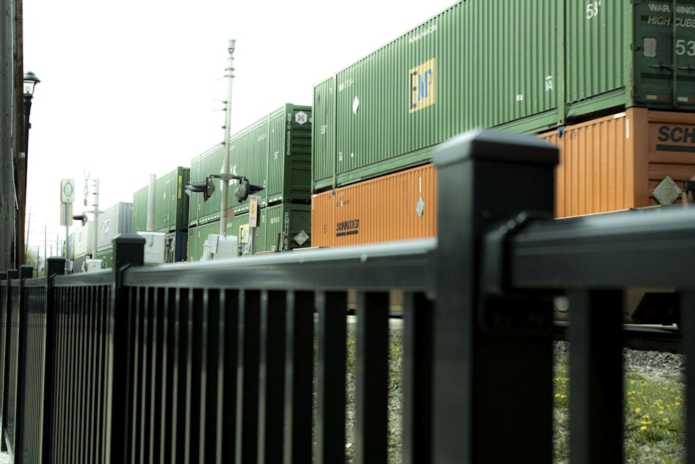 a fence with a bunch of cargo containers on top of it