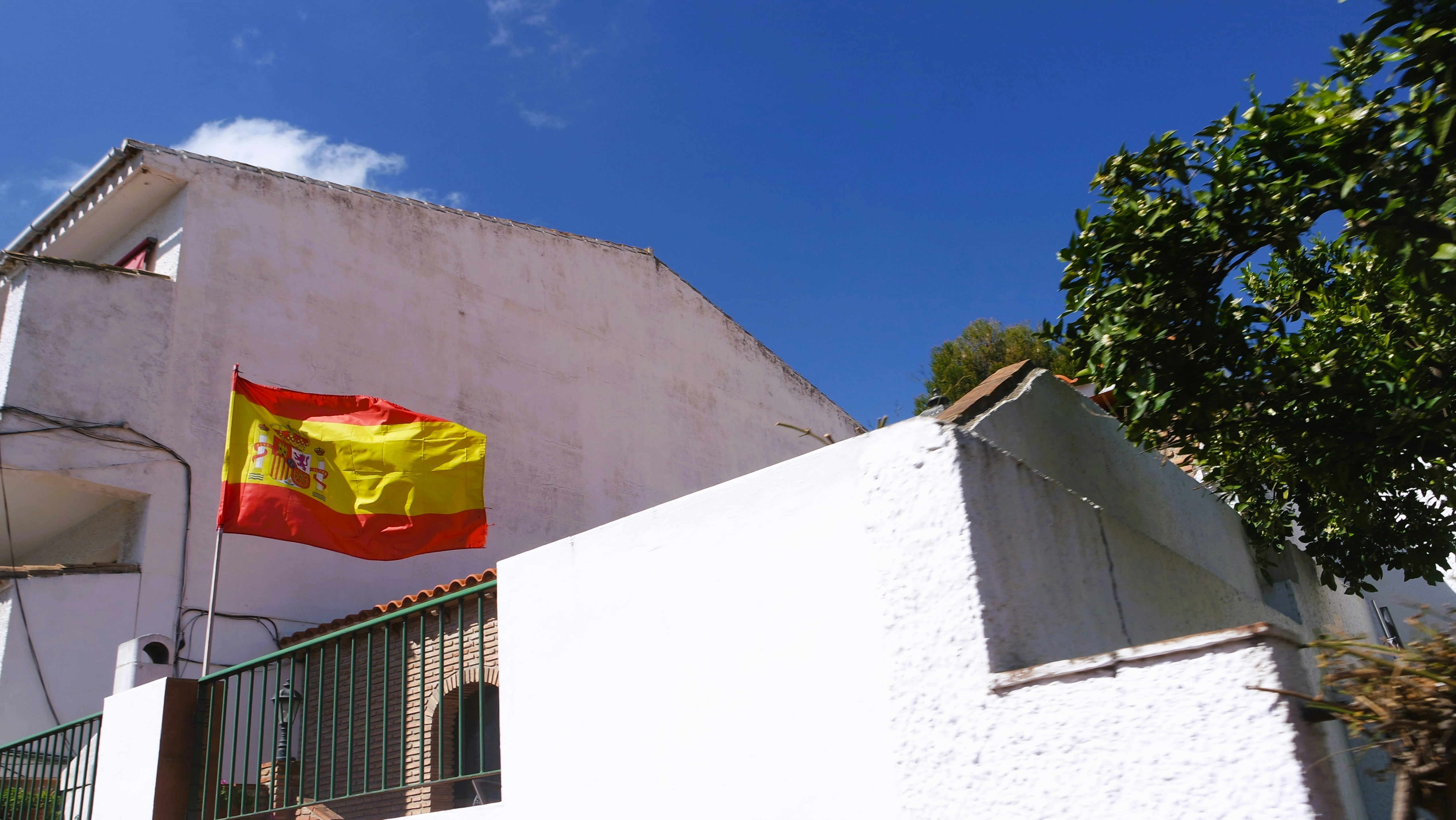 a yellow and red flag on a white building