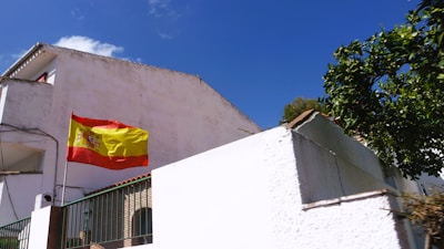 a yellow and red flag on a white building
