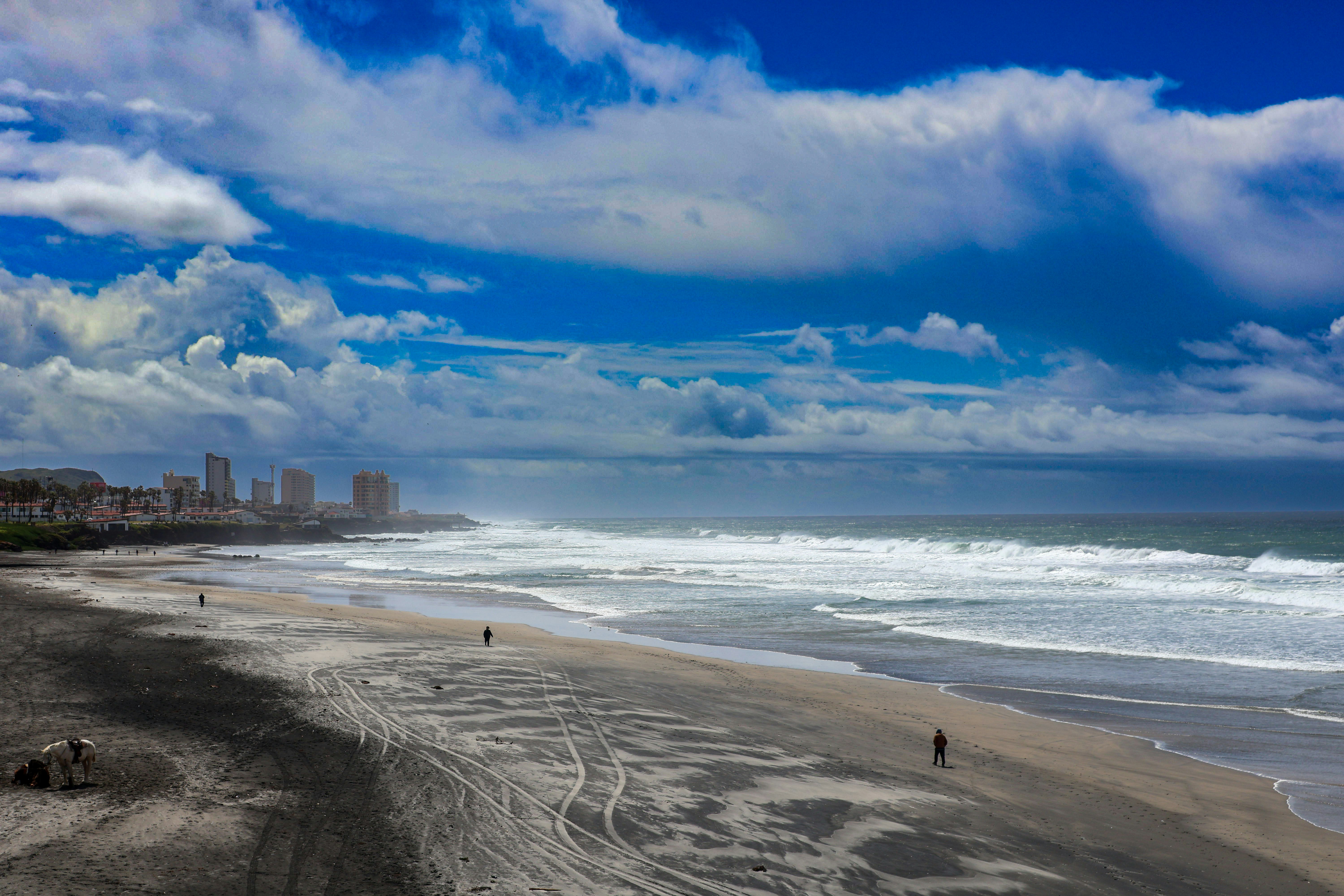 a beach with a few people walking on it