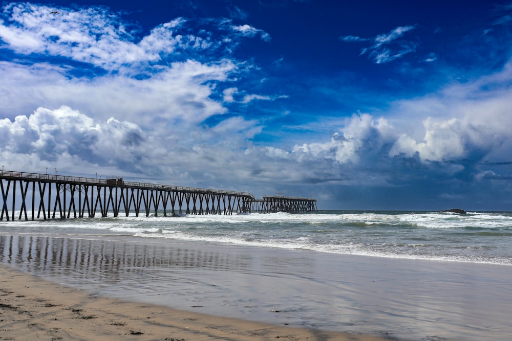 a long pier stretches out into the ocean