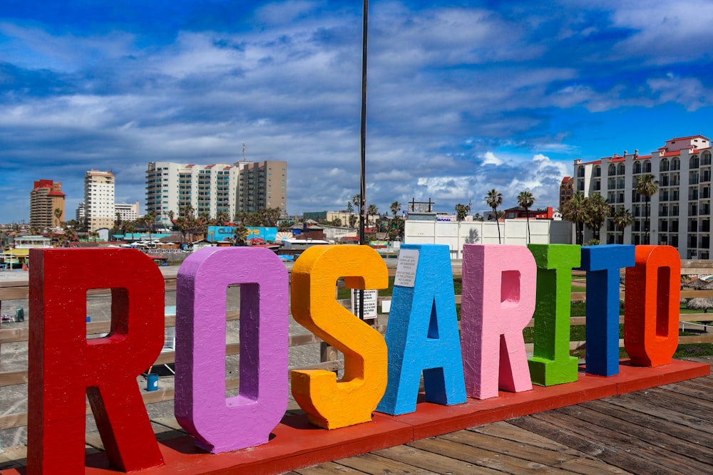 a colorful sign that says rosarto on a boardwalk