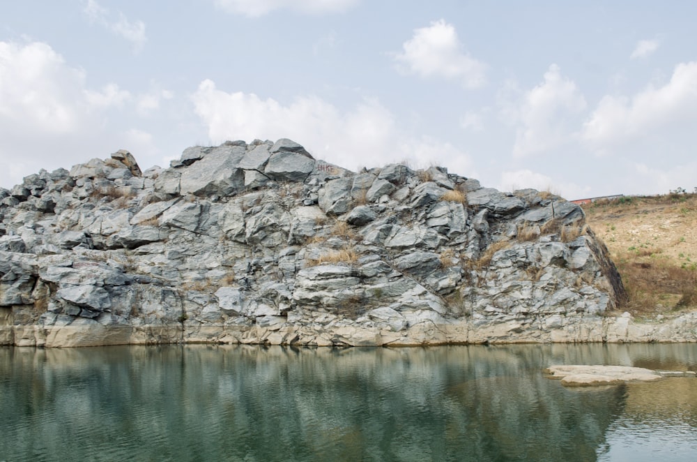 a large rock formation next to a body of water