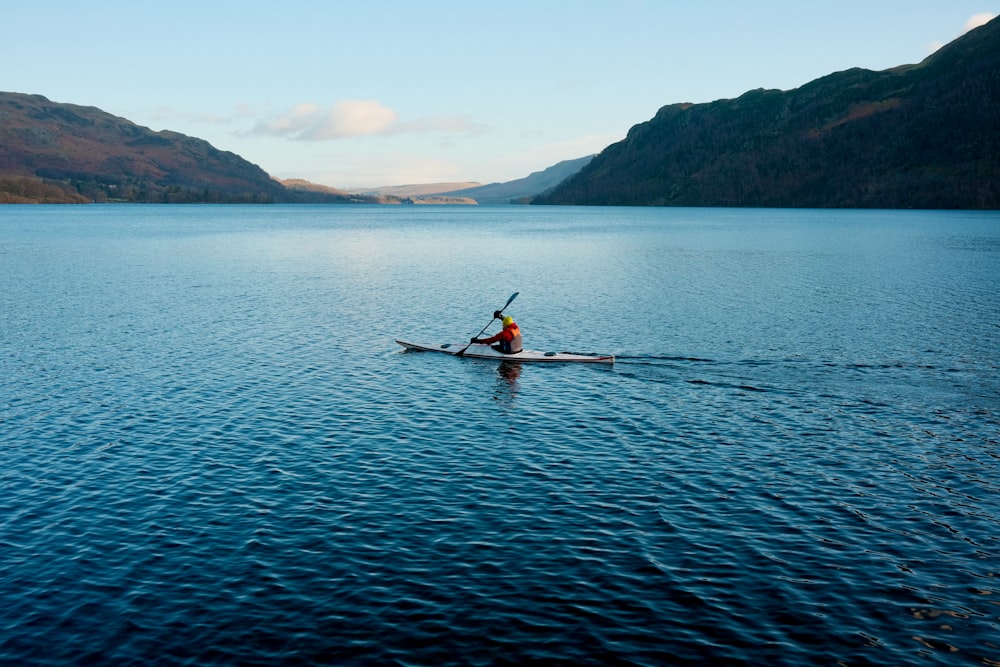 a person in a kayak paddling on a large body of water